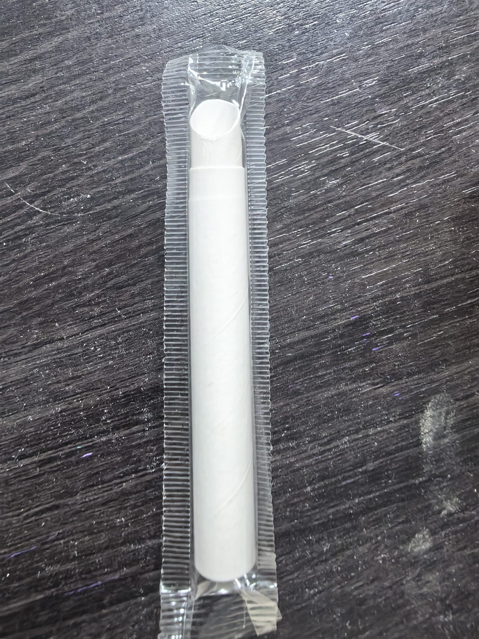 Actual compact telescopic paper straw sample in individual wrapper